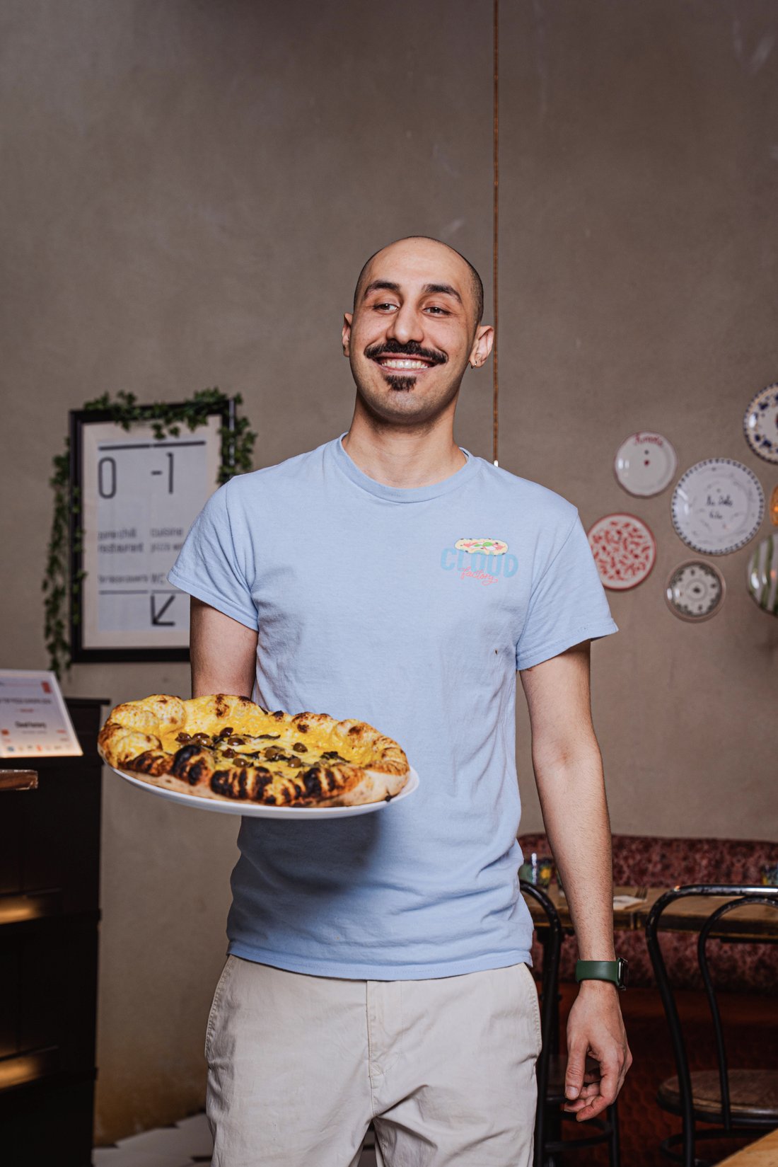 A Cloud Factory waiter carrying a pizza